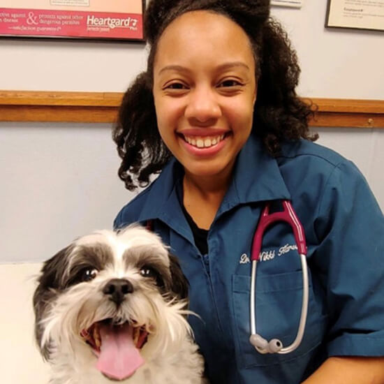 Dr. Nikki Harville A woman and a dog both posing and smiling for the camera