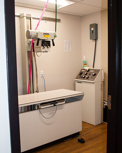 A room with an examination table and radiology equipment
